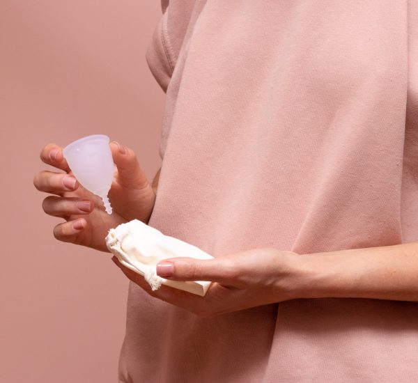 person in pink long sleeve shirt holding white heart ornament